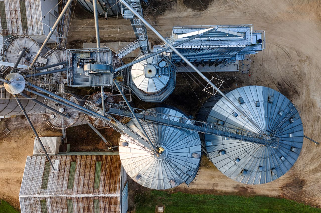 Drone shot of metal grain silos in Utica, MN, showcasing industrial agriculture.